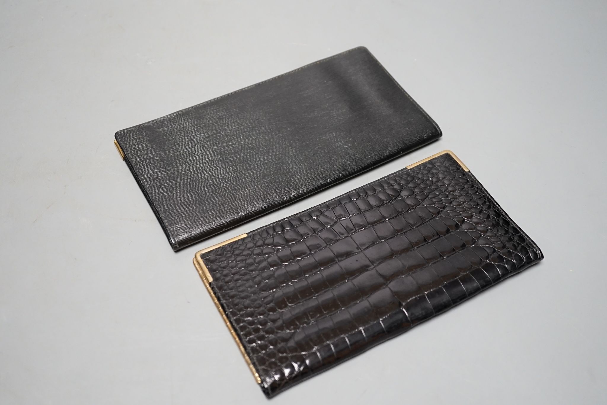 An Alfred Dunhill gold plate mounted leather wallet, 18.9cm, and one other 9ct gold mounted leather wallet initialled J.B.S., 17.9cm.